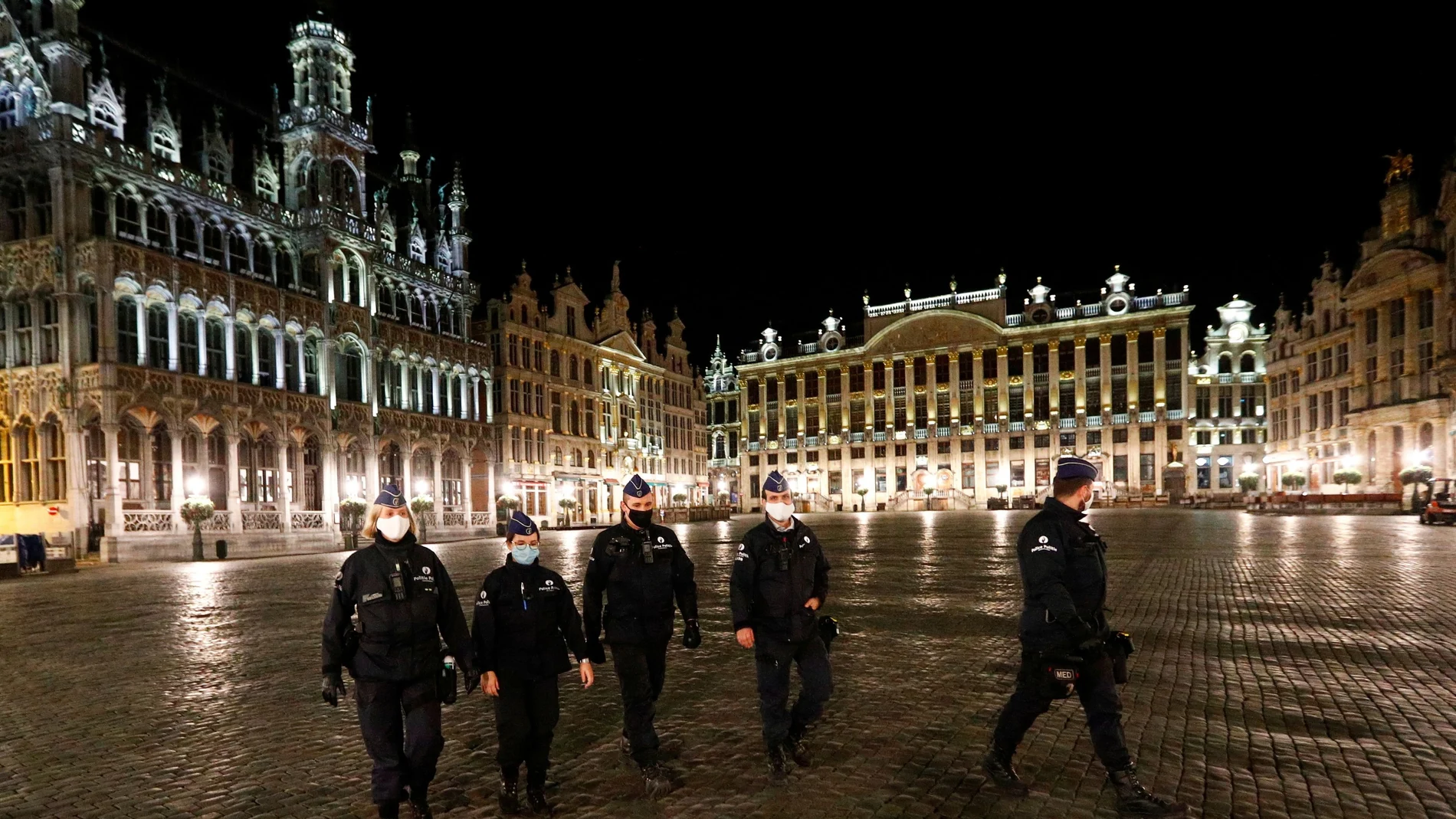 Varios agentes de policía patrullan la Grand Place de Bruselas por la noche