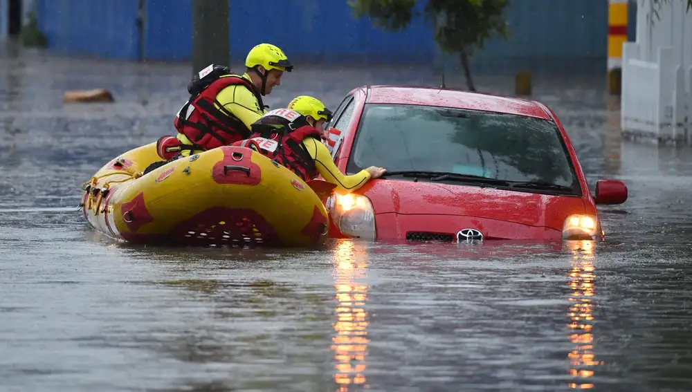 Los bomberos buscan supervivientes en un coche que ha quedado bloqueado por las inundaciones