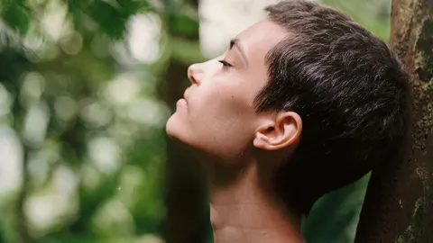 En la imagen, una mujer respirando de forma consciente.