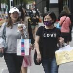 Gente con mascarillas y sin ellas ed compras por la zona comercial de Taipéi, en Taiwán