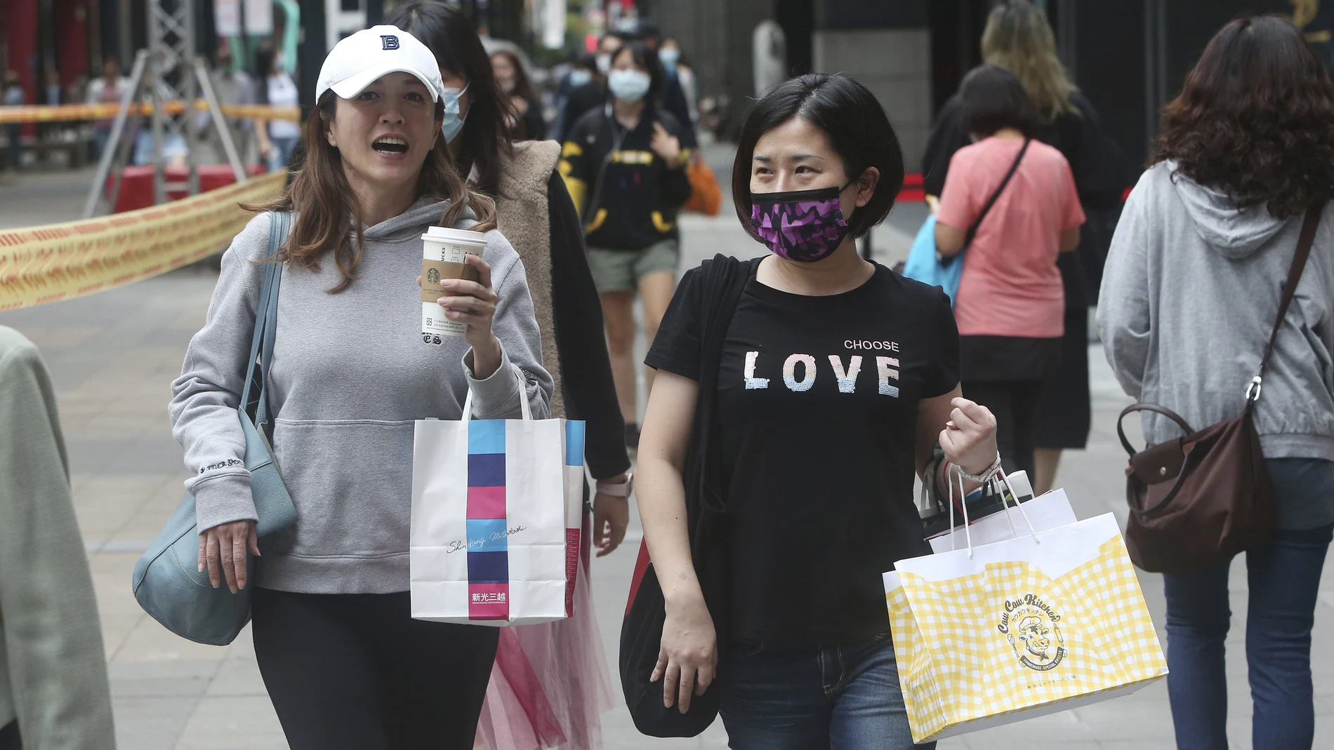 Gente con mascarillas y sin ellas ed compras por la zona comercial de Taipéi, en Taiwán