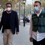 Agentes de la Guardia Civil custodian exalto cargo de CDC David Madí (i) a su llegada a su despacho profesional tras ser detenido