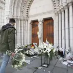 El atentado contra una basílica en Niza demuestra que la Iglesia católica es objetivo permanente de los yihadistas. En la imagen, flores depositadas ante la puerta del templo EFE/EPA/SEBASTIEN NOGIER