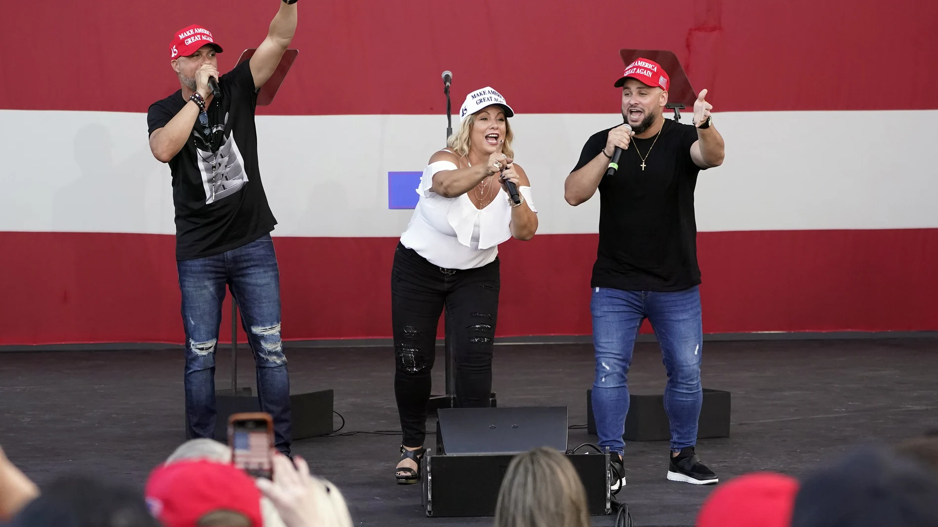 FILE- In this Tuesday, Oct. 27, 2020 file photo, members of the Cuban musical group Los 3 de La Habana, German Pinelli, left, Ana Paez, center, and Tirso Luis, right, sing during a "Make America Great Again!" event with Ivanka Trump at Bayfront Park Amphitheater, in Miami. Florida's Cuban American voters remain a bright spot in Trump's effort to retain his winning coalition from 2016. Polls show his strong support from these key voters may even be growing to include the younger Cuban Americans that Democrats once considered their best hope of breaking the GOP's hold. The musicians say Trumpâ€™s economic and foreign policies have been his main achievements. (AP Photo/Wilfredo Lee, File)