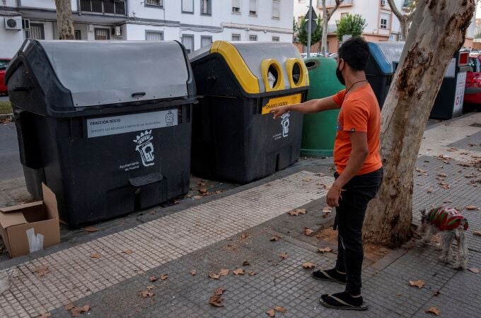Un hombre ante el contenedor de basura de Huelva donde se ha hallado una bolsa de basura con restos humanos