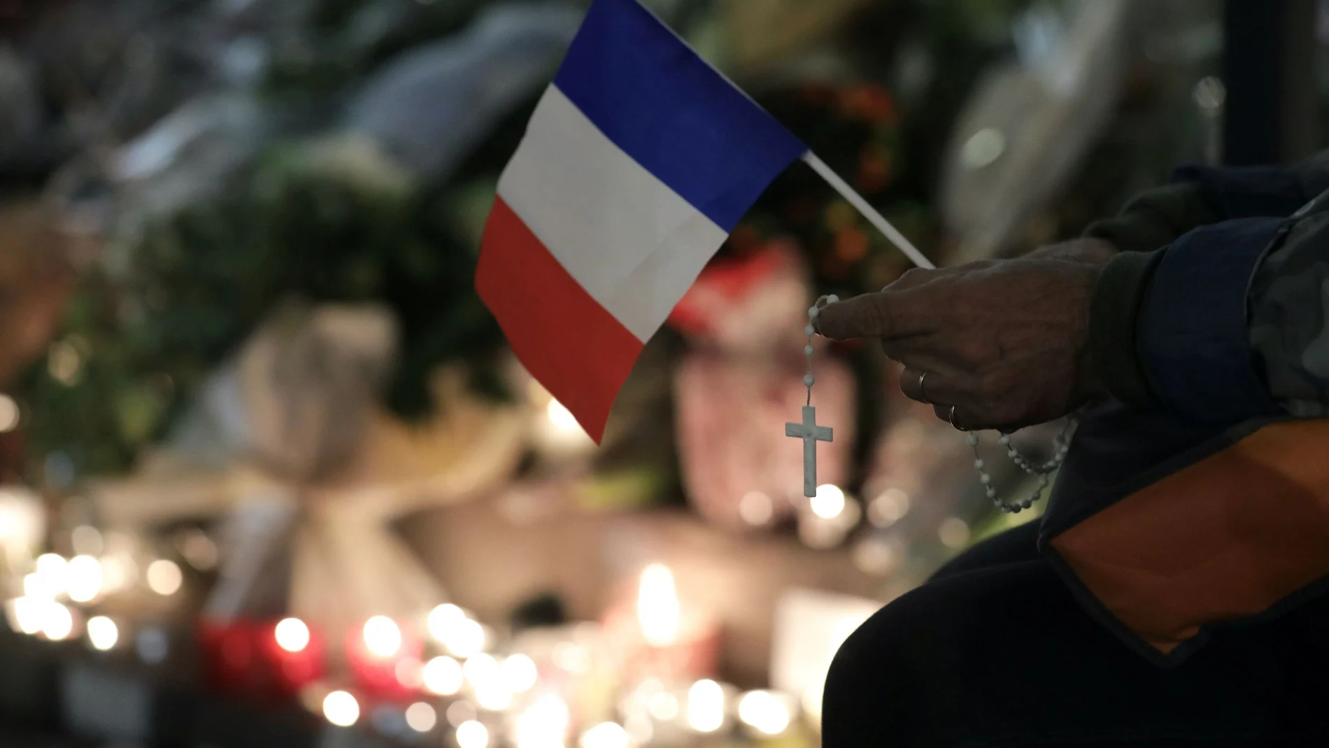 Un hombre reza frente a la iglesia de Notre Dame en Niza para rendir homenaje a las víctimas mortales