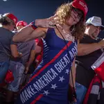 Una mujer lleva hoy un vestido con el lema de campaña del presidente Trump &quot;Make America Great Again&quot;, este domingo durante un acto de campaña en Opa-locka, localidad ubicada en el condado de Miami-Dade, Florida
