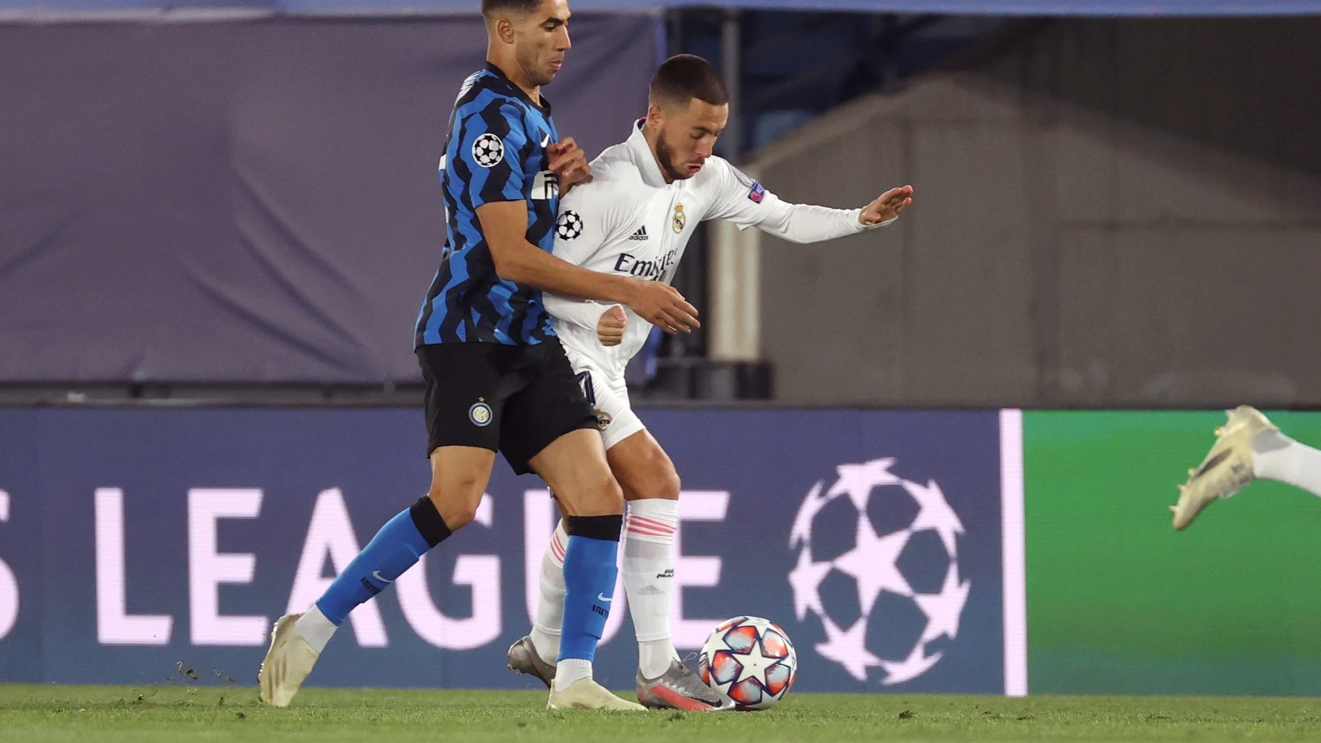 El defensa marroquí del Inter, Achraf Hakimi (i) presiona al centrocampista belga del Real Madrid, Eden Hazard, durante el partido de la fase de grupos de la Liga de Campeones que se disputa este martes en el estadio Alfredo di Stéfano. EFE/JuanJo Martín