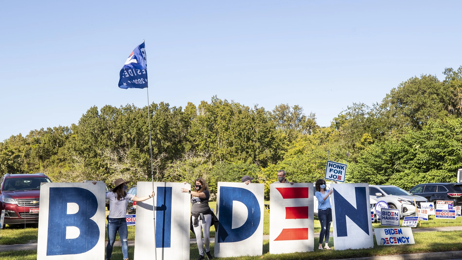 Unas voluntarias sostienen unas letras gigantes con el logo de Biden en Seminole County East Branch