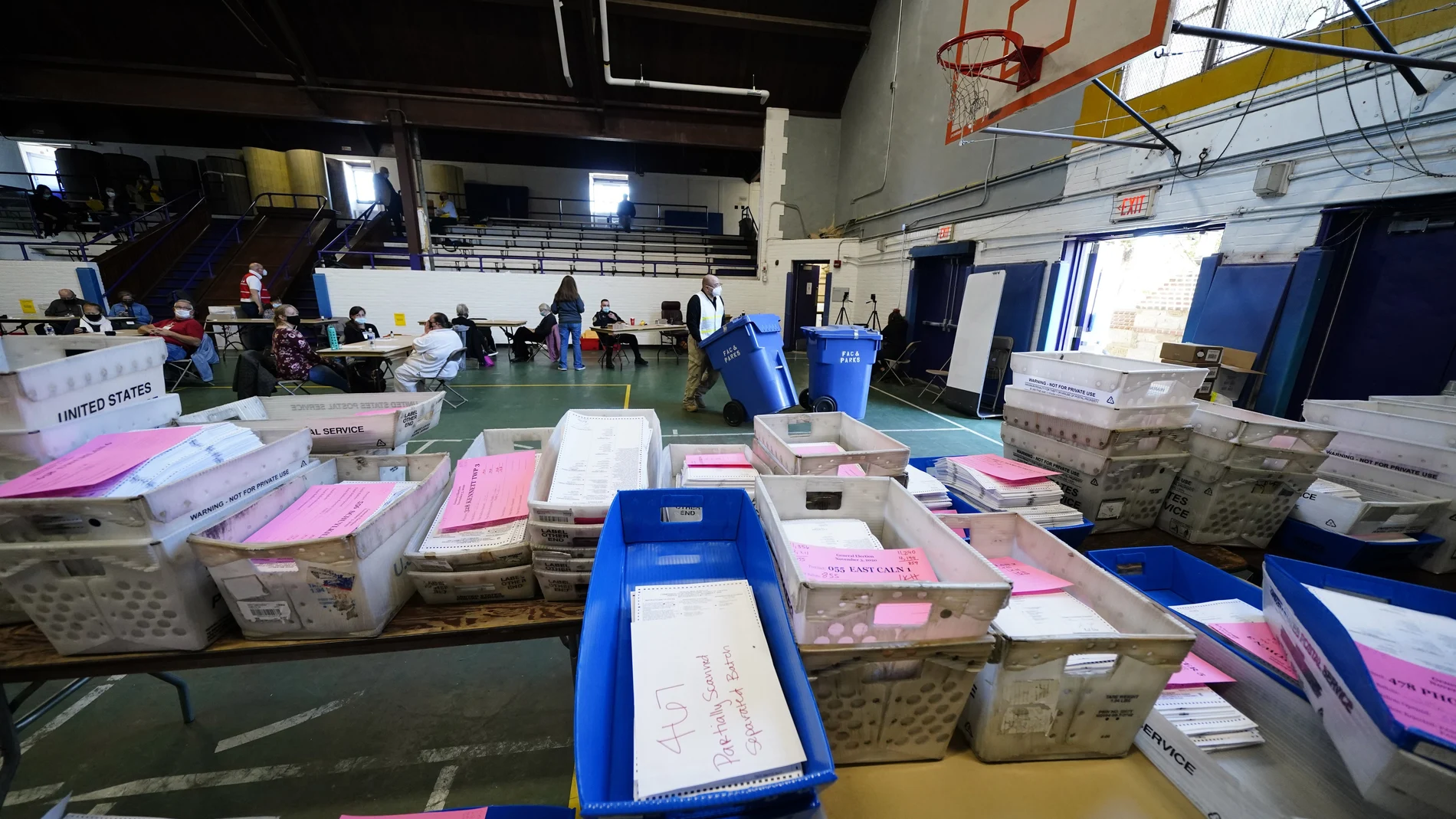 Trabajadores procesan las papeletas de voto por correo en el polideportivo de la Universidad de West Cheste.