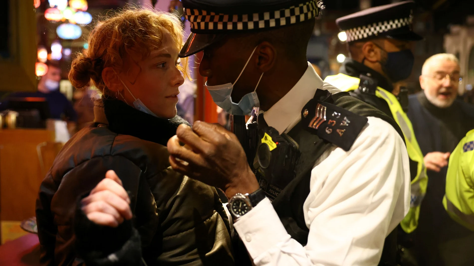 Un policía habla con una mujer a la salida de un pub en Londres