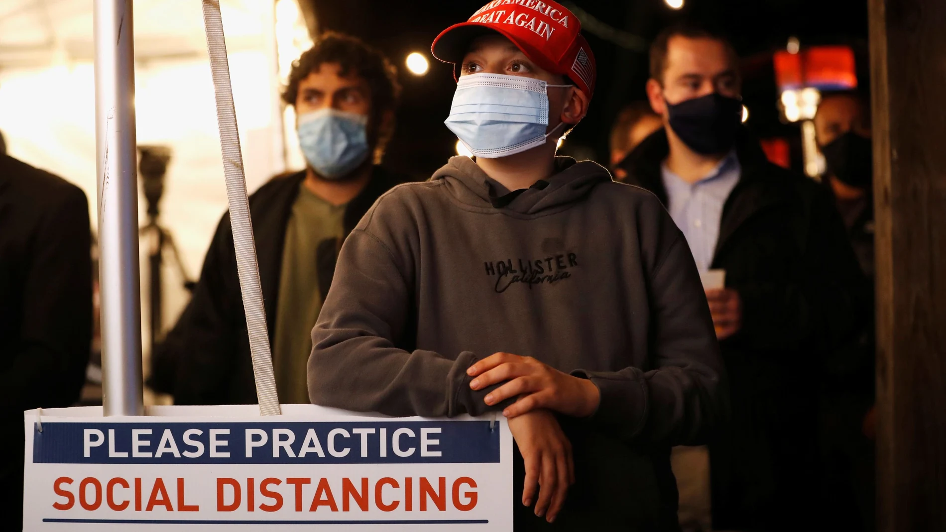 Personas con mascarillas siguen el recuento electoral en en New York