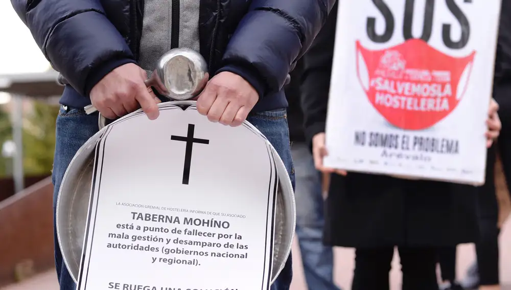 VALLADOLID, 05/11/2020.- Un cocinero sostiene una cacerola y la esquela de un negocio durante la concentración convocada este jueves por los hosteleros ante la sede de la Cortes de Castilla y León, en Valladolid, en protesta por el cierre de su sector desde este viernes y durante al menos 14 días para intentar frenar la expansión descontrolada del coronavirus. EFE/NACHO GALLEGO