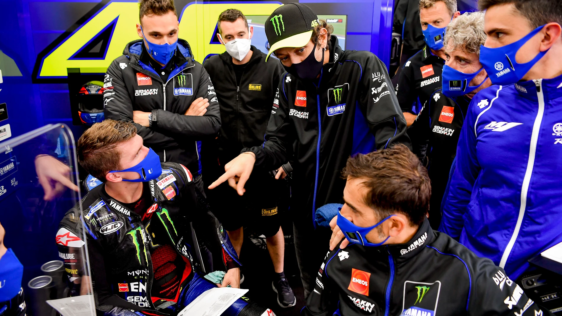 Valentino Rossi, en su box, rodeado de su equipo y todos con mascarilla