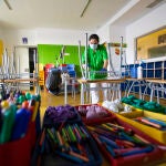Una mujer limpia un aula en el colegio Arenales de Carabanchel