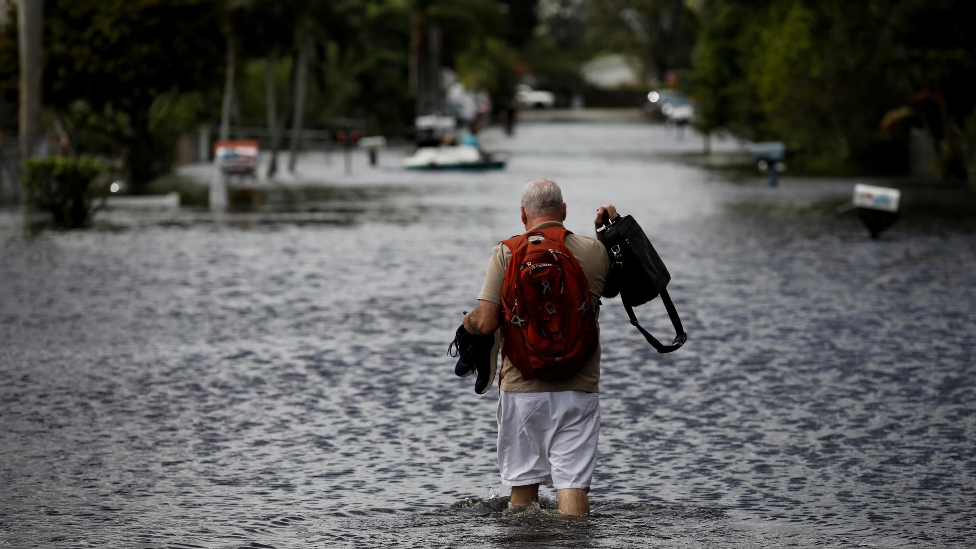 Un hombre camina por las inundaciones causadas por la tormenta tropical ETA en Davie, Florida