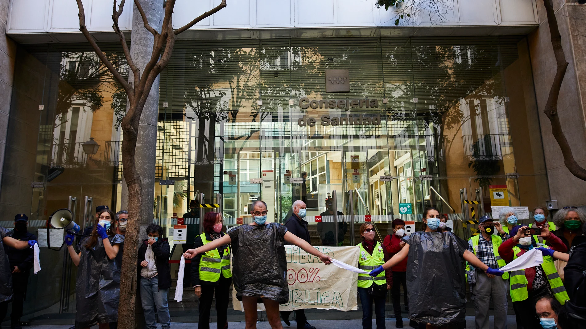Trabajadores sanitarios vestidos con bolsas de basura como signo de protesta en una concentración frente a la Consejería de Sanidad, en Madrid