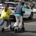 Dos personas van en patinete eléctrico.