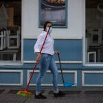 Una camarera tras recoger el mobiliario de la terraza de un bar