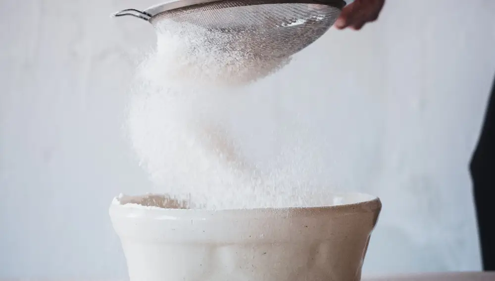 En la imagen, un hombre tamizando azúcar.