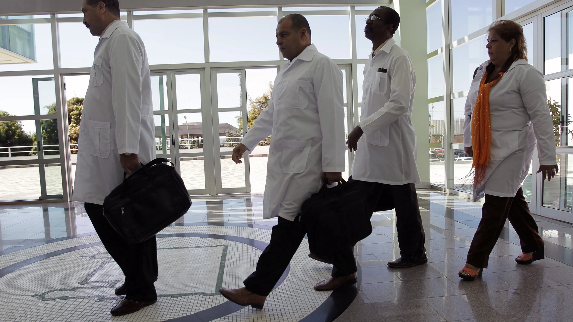 FILE - In this Aug. 26, 2013 file photo, Cuban doctors arrive for training before being assigned to work in impoverished areas where physicians and medical services are scarce, at the University of Brasilia in Brasilia, Brazil. A federal judge paved the way on Monday, Nov. 9, 2020, for a lawsuit against the Pan American Health Organization for its alleged role in the human trafficking of Cuban doctors to Brazil between 2013 and 2018 to be heard in the United States courts. (AP Photo/Eraldo Peres, File)