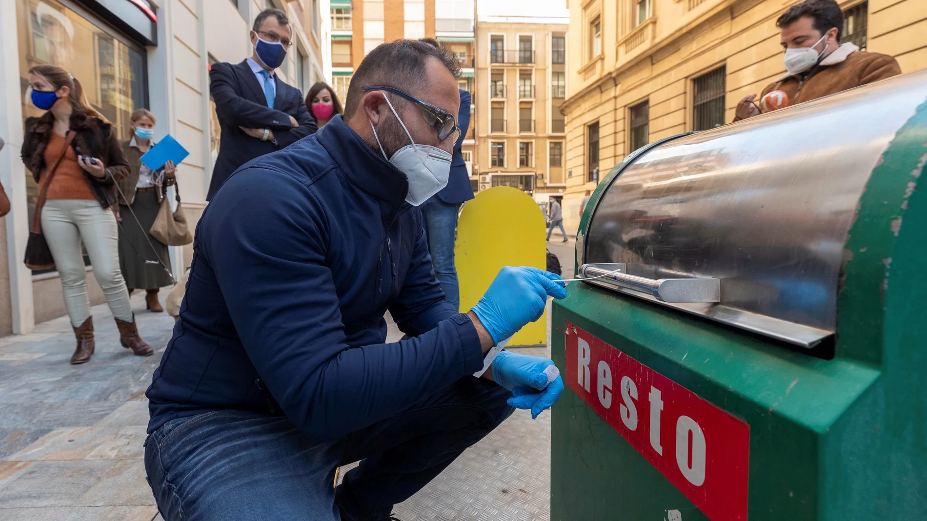 GRAF8404. MURCIA, 12/11/2020.- Un técnico de la empresa de limpieza del ayuntamiento de Murcia recoge una muestra de un contenedor de basura este jueves en el centro de la ciudad, para el análisis y la detección de trazas de COVID-19 que se va a llevar a cabo en los contenedores y papeleras del municipio para garantizar la seguridad de los vecinos a la hora de utilizar dicho mobiliario urbano y de los trabajadores del servicio de basuras EFE/Marcial Guillén