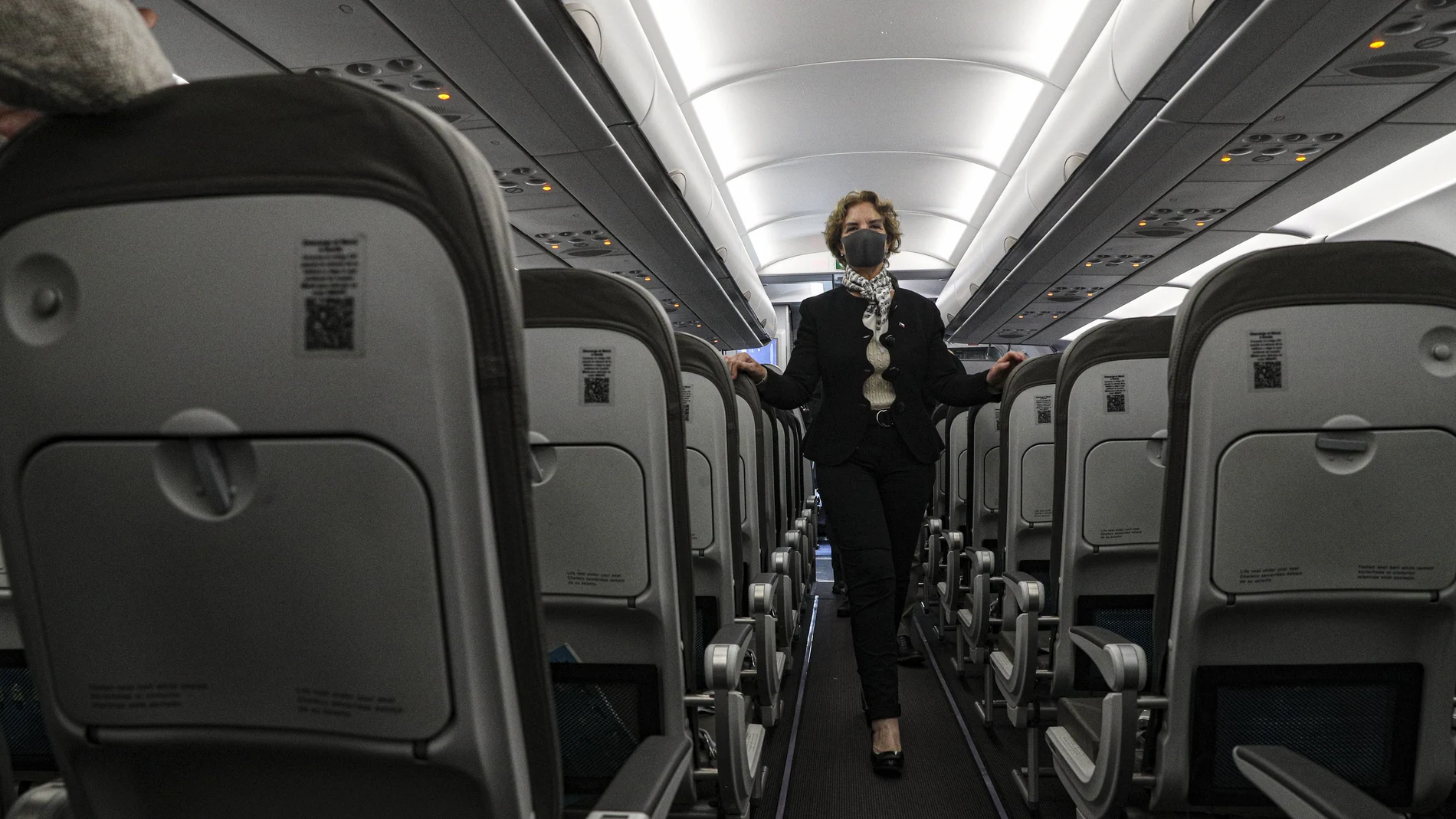 Transportation and Communications Minister Gloria Hut walks inside a Jet Smart plane during a photo opportunity after her press conference announcing the reopening of the Arturo Merino Benitez International Airport amid the COVID-19 pandemic in Santiago, Chile, Friday, Nov. 13, 2020. Hut announced that starting Nov. 23, non-resident passengers who bring a negative COVID-19 test will be allowed to fly to Chile. (AP Photo/Esteban Felix)
