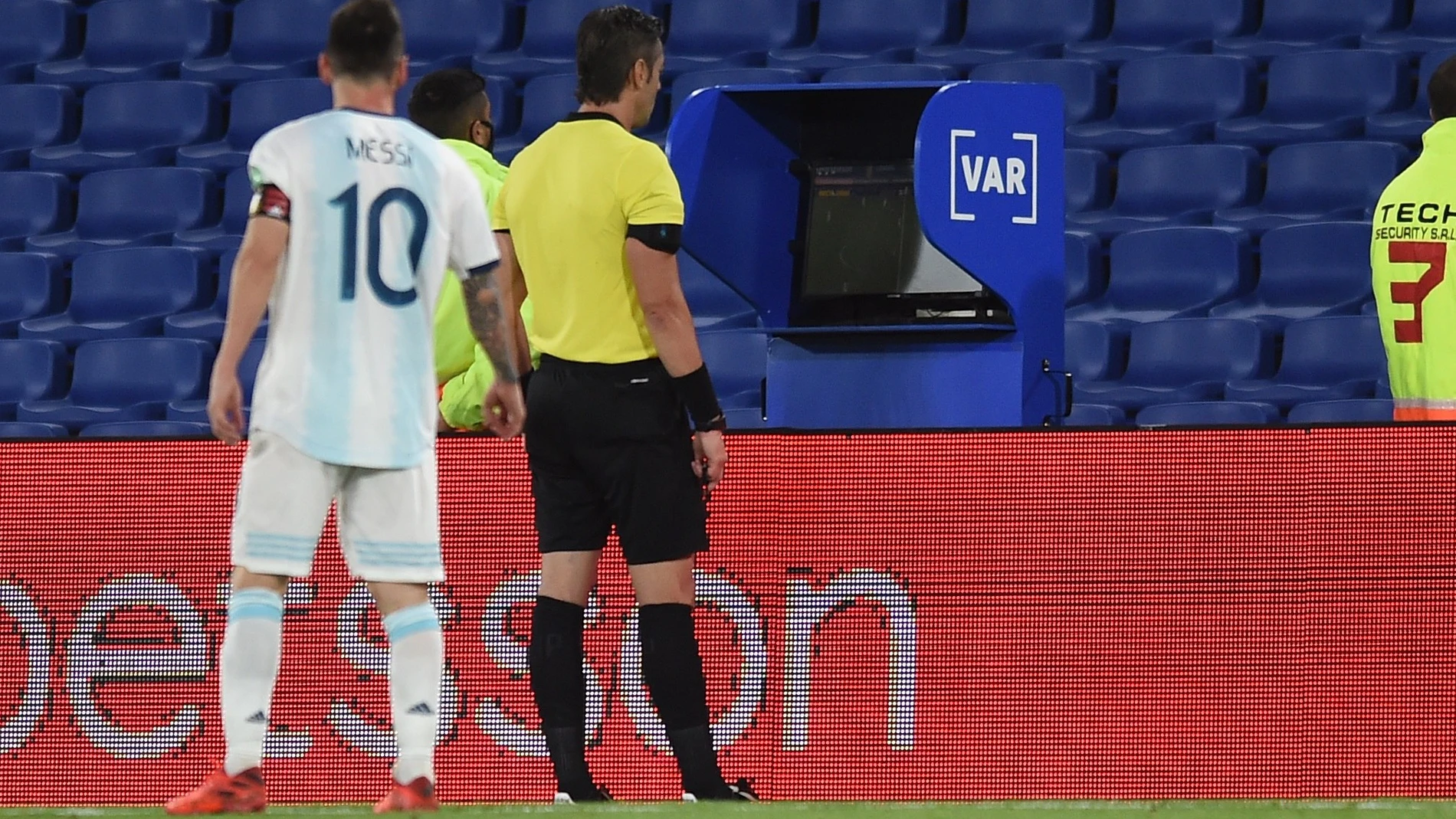 Leo Messi observa la pantalla del VAR detrás del árbitro Raphael Claus.