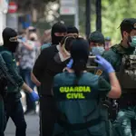 Agentes de la Guardia Civil totalmente protegidos detienen a un presunto yihadista en Barcelona.