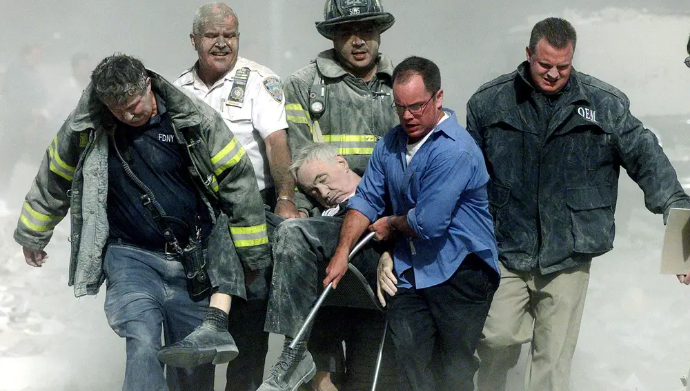 Rescatadores y bomberos cargan con una víctima de los atentados del 11-S