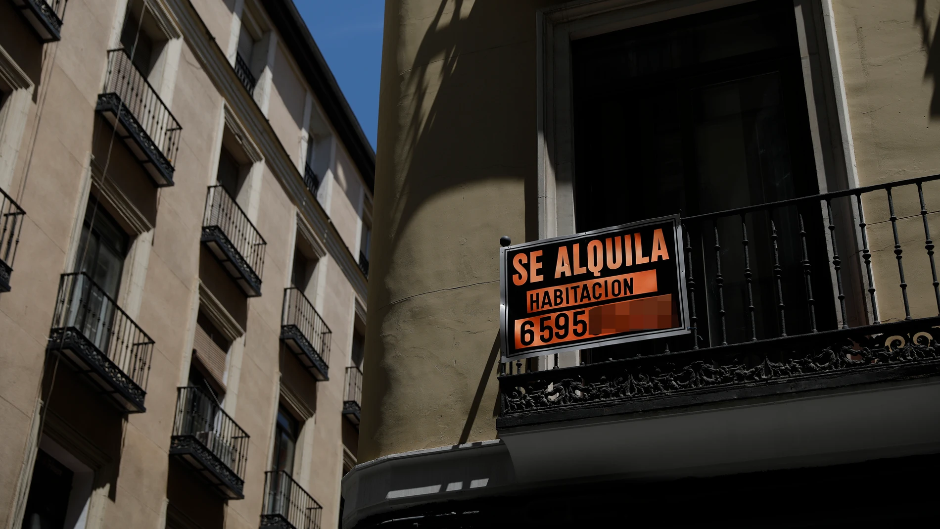 Imagen de un balcon en el barrio de Chueca en el que se anuncia el alquiler de una habitacion.