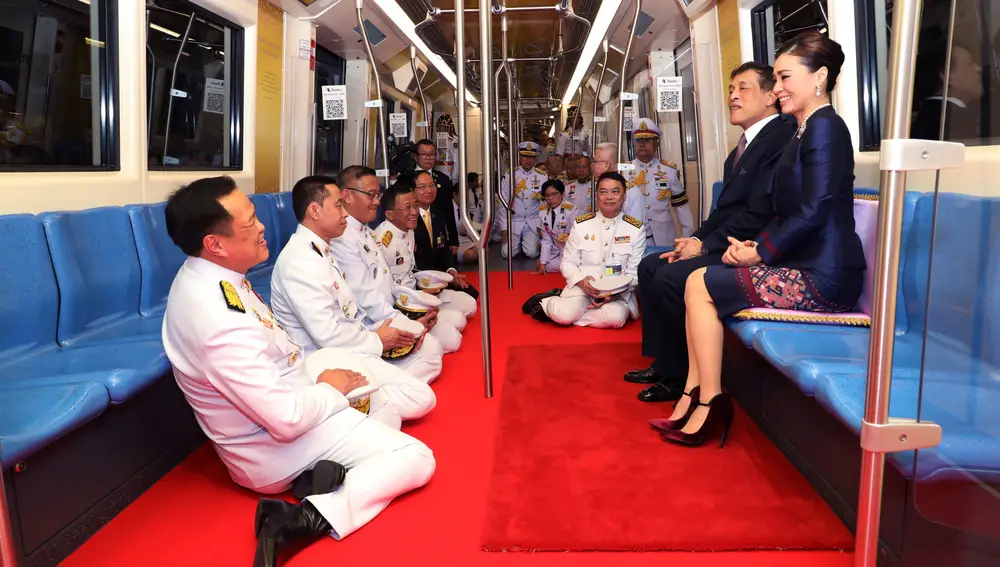 El rey Maha Vajiralongkorn y la reina Suthida rodeados de funcionarios arrodillados ante ellos durante la inauguración de una nueva estación de metro en Bangkok, este mes