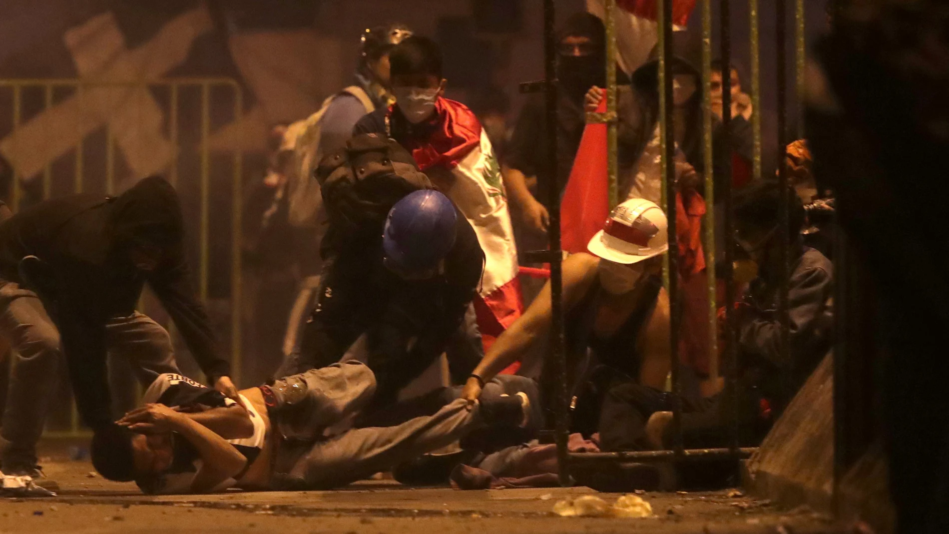 Un manifestante es ayudado tras resultar herido durante los enfrentamientos con la policía por la destitución del presidente de Perú ayer en Lima.
