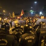 Policías frente a manifestantes que se niegan a reconocer al nuevo Gobierno de Perú en Lima, ayer por la noche