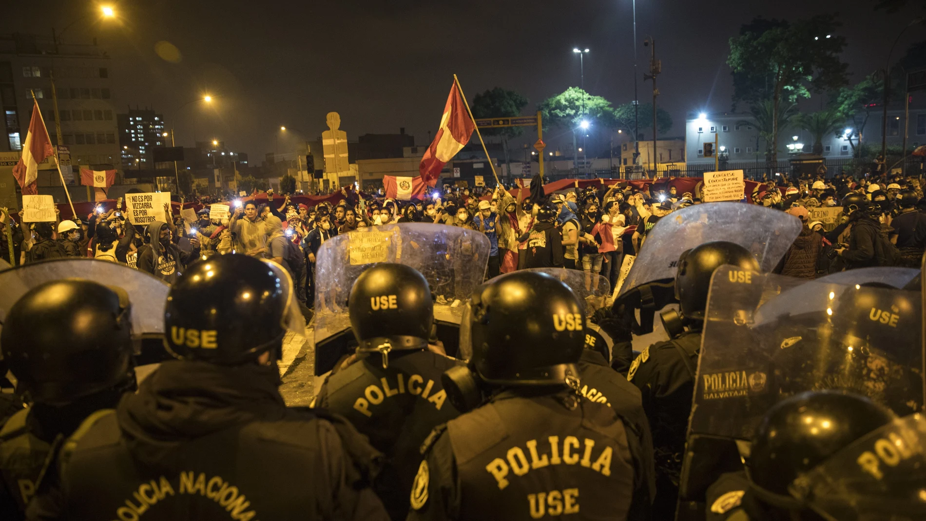 Policías frente a manifestantes que se niegan a reconocer al nuevo Gobierno de Perú en Lima, ayer por la noche