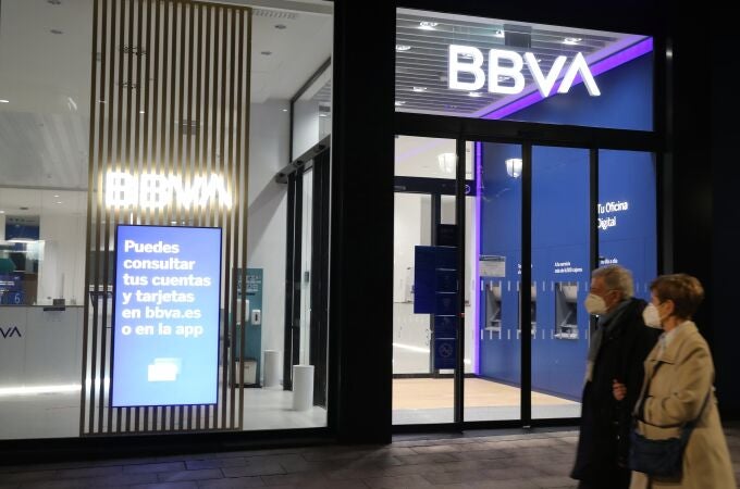Una pareja pasa frente a una oficina del BBVA, este lunes en Bilbao