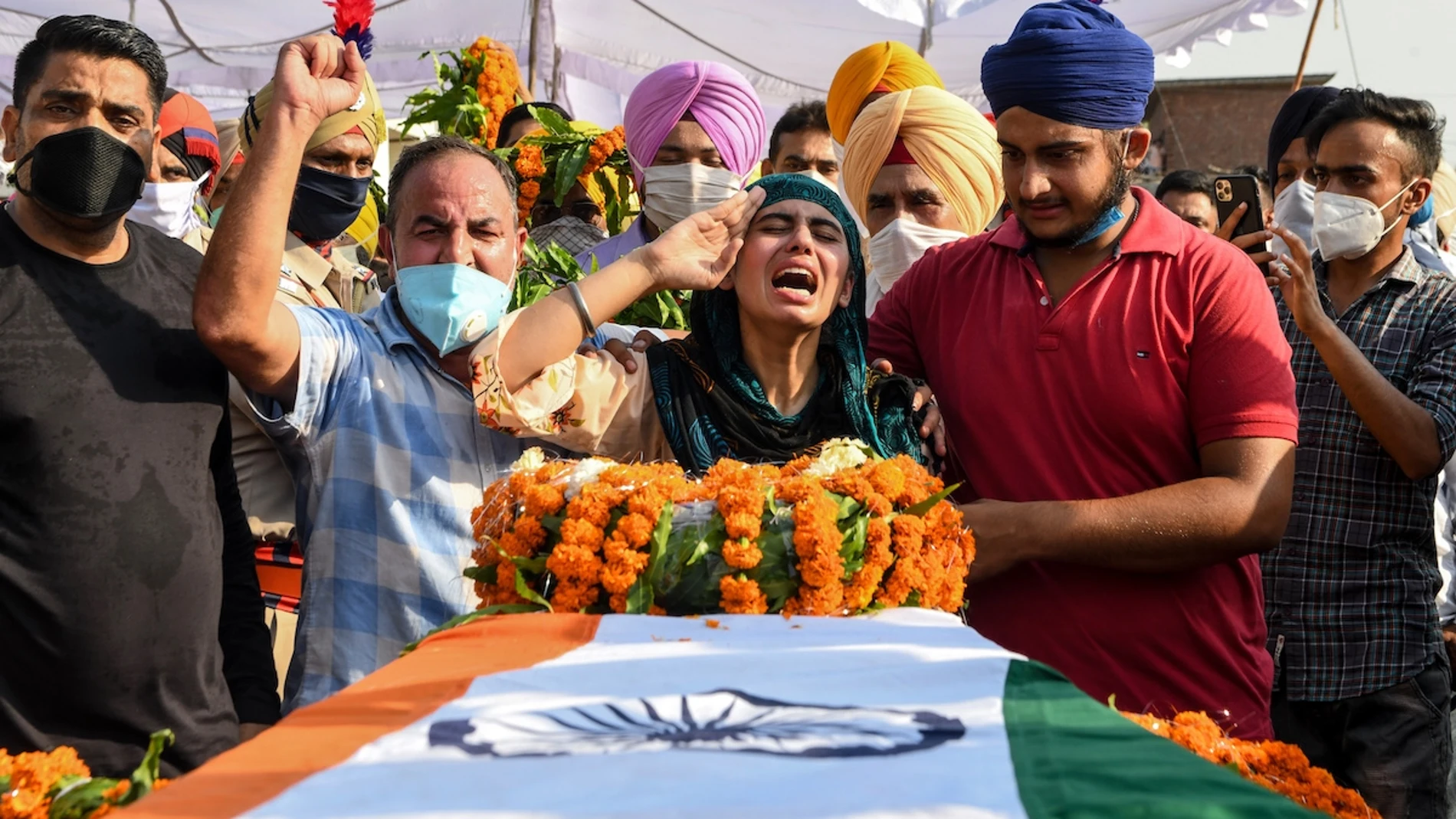 Sandeep Kaur (C) y su hermono Prabhjot Singh (2D) lamentan la muerte de su padre, el soldado Satnam Singh, quien murió en recientes choques con fuerzas chinas en la zona de Galwan, durante la ceremonia de cremación en Bhojraj, el 18 de junio de 2020. (AFP / Narinder Nanu)