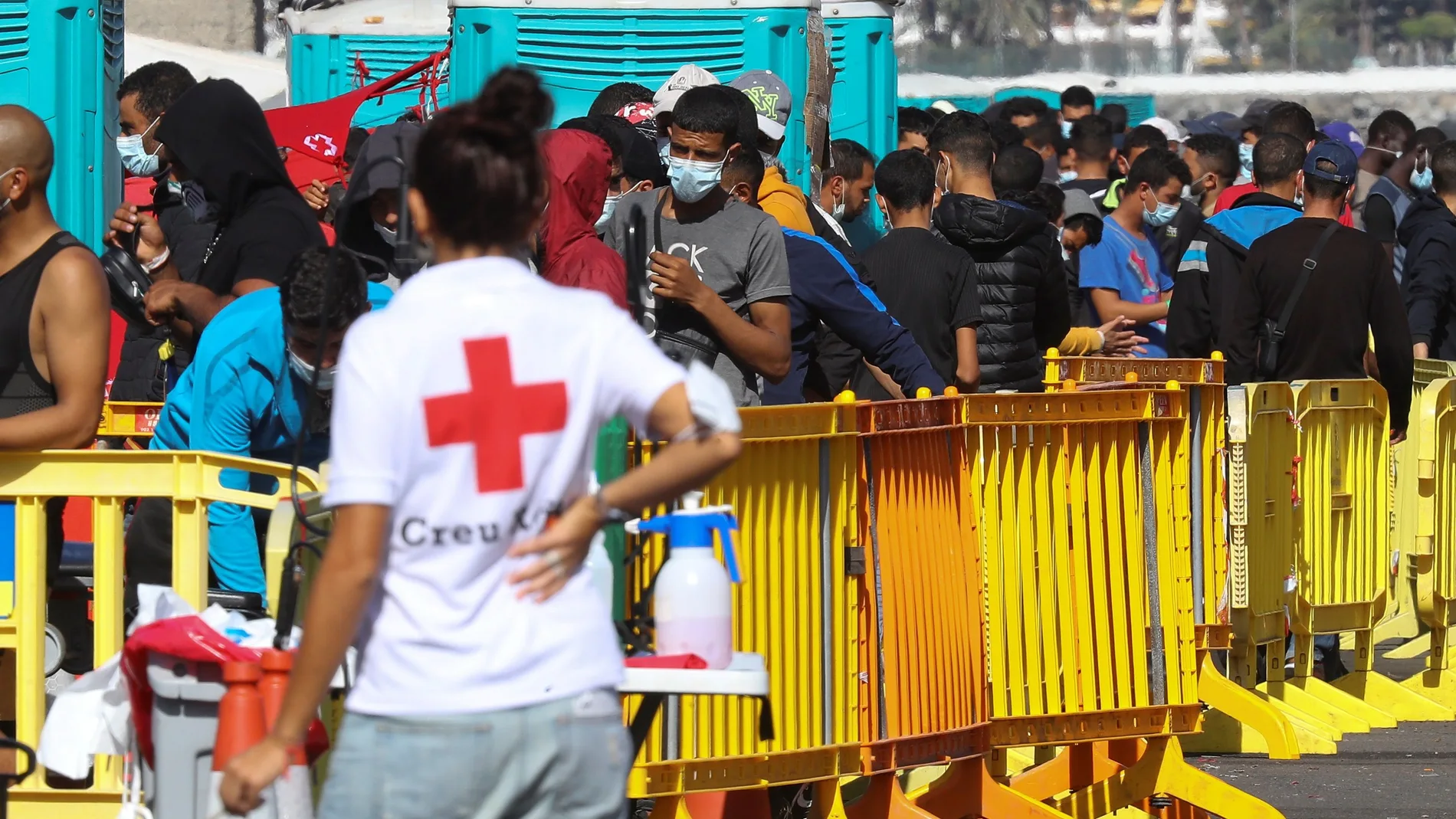 Una voluntaria de Cruz Roja junto a varios inmigrantes este jueves en el muelle de Arguinegu�n. EFE/ Elvira Urquijo A.