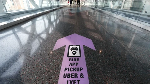 Travelers walk across a nearly empty skyway bridge towards the Uber and Lyft shared ride pick-up point at Logan Airport, Friday Nov. 20, 2020, in Boston. With the coronavirus surging out of control, the nation's top public health agency pleaded with Americans not to travel for Thanksgiving and not to spend the holiday with people from outside their household. (AP Photo/Michael Dwyer)