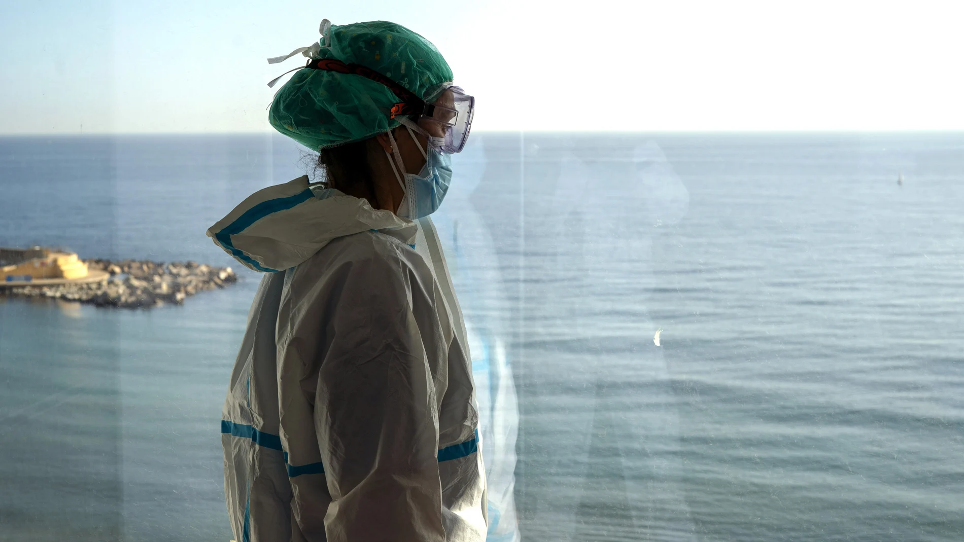 La enfermera Marta Fernández mira a través de una ventana del Hospital del Mar. (AP Photo/Emilio Morenatti)