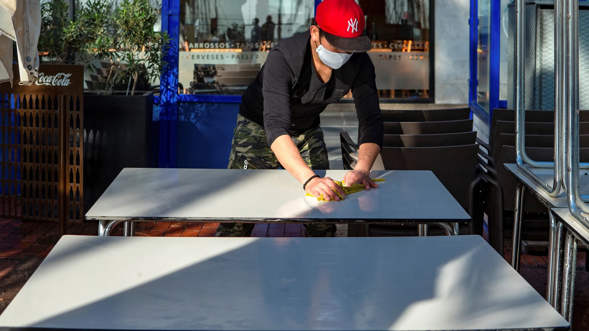Empleados y propietarios preparan locales de restauración hoy sábado a la espera del inicio de la desescalada y cuando la Generalitat publica la resolución que permite abrir a partir del lunes a bares y restaurantes con limite de aforo pero ininterrumpidamente hasta las 21.30, poco antes del inicio del toque de queda, que permanece inalterable. EFE/ Enric Fontcuberta.