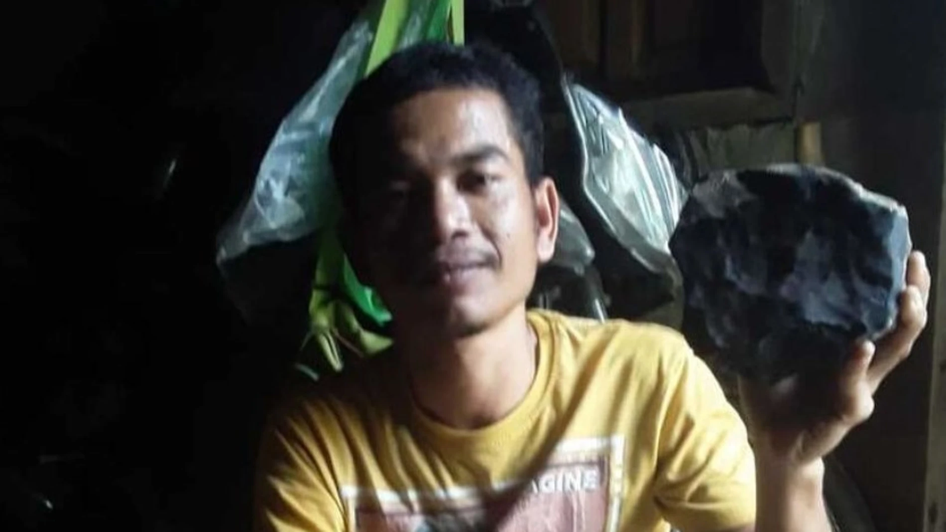 Josua Hutagalung con la piedra de 2.1 kg que atravesó el tejado de su casa en Indonesia.