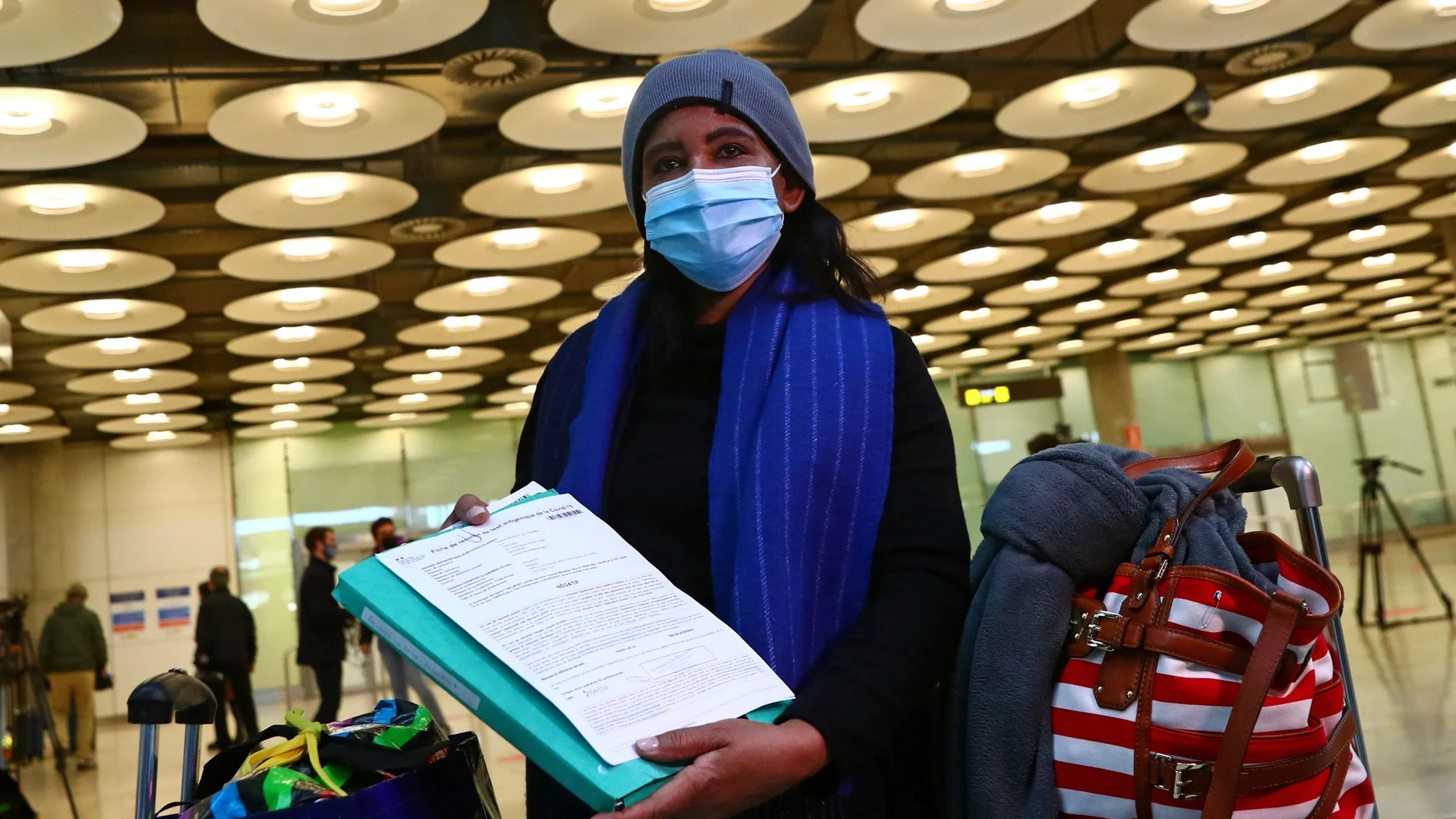 Una pasajera muestra el resultado negativo de su PCR en el aeropuerto Adolfo Suarez Barajas, en Madrid