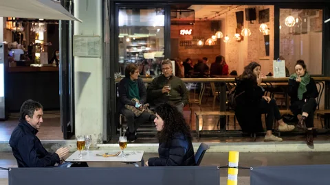 Varias personas conversan en la terraza de un bar de Barcelona