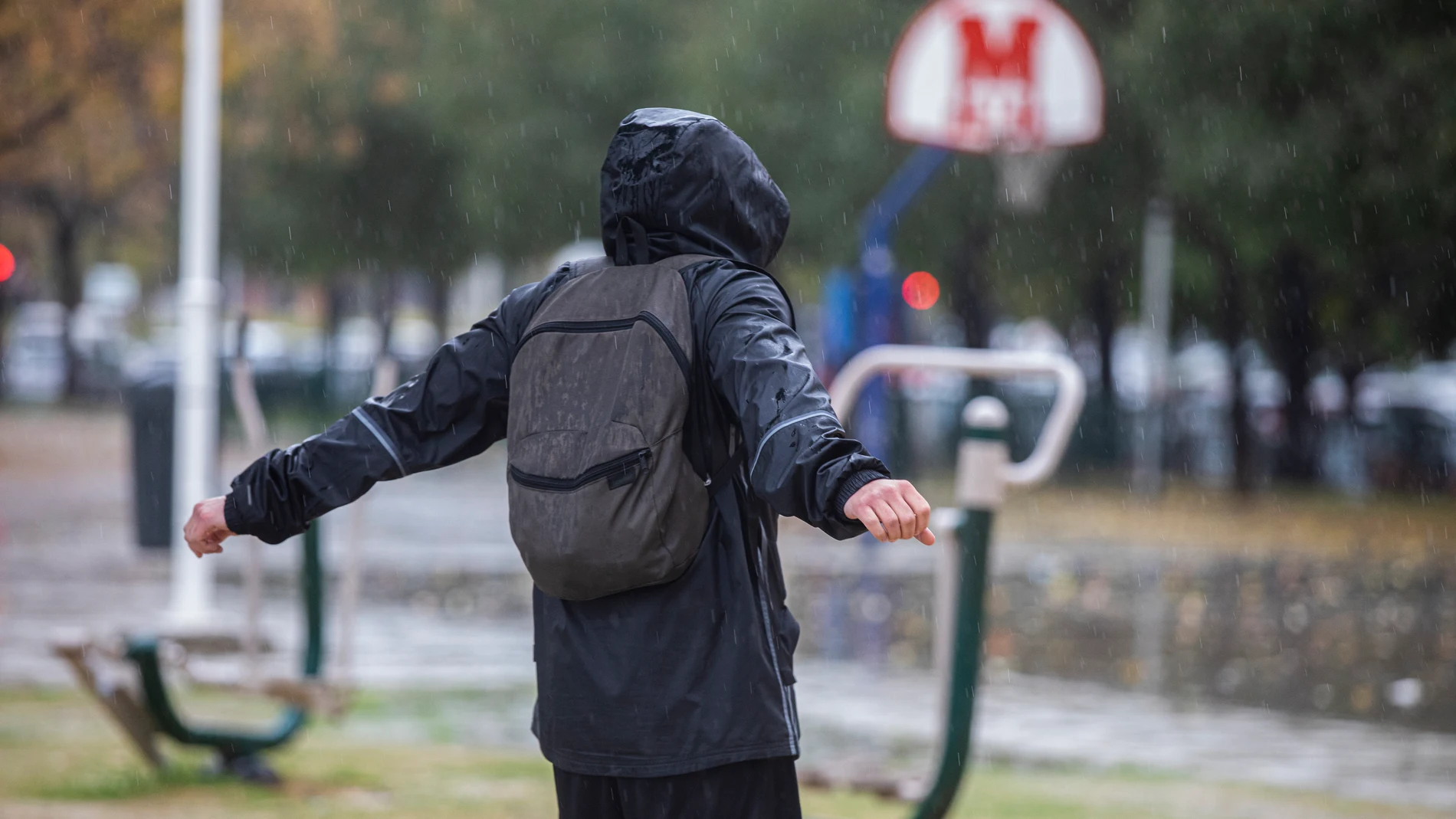 Una persona con un chubasquero bajo la lluvia