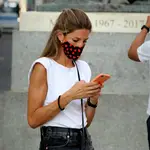 Una joven consulta su móvil en la madrileña Puerta del Sol