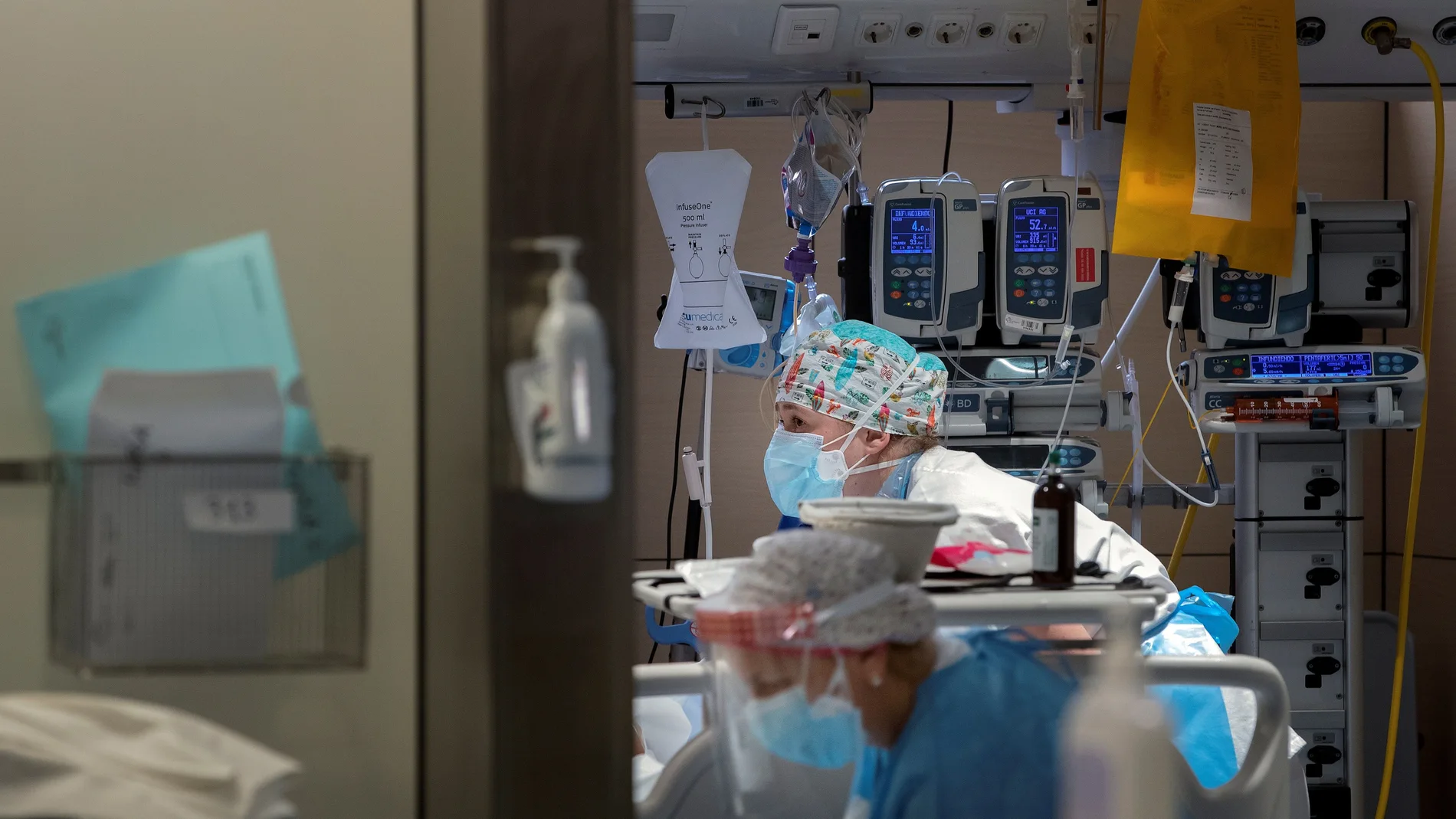 Dos profesionales sanitarios trabajan en la UCI del Hospital Vall d'Hebron de Barcelona. EFE/Alberto Estévez