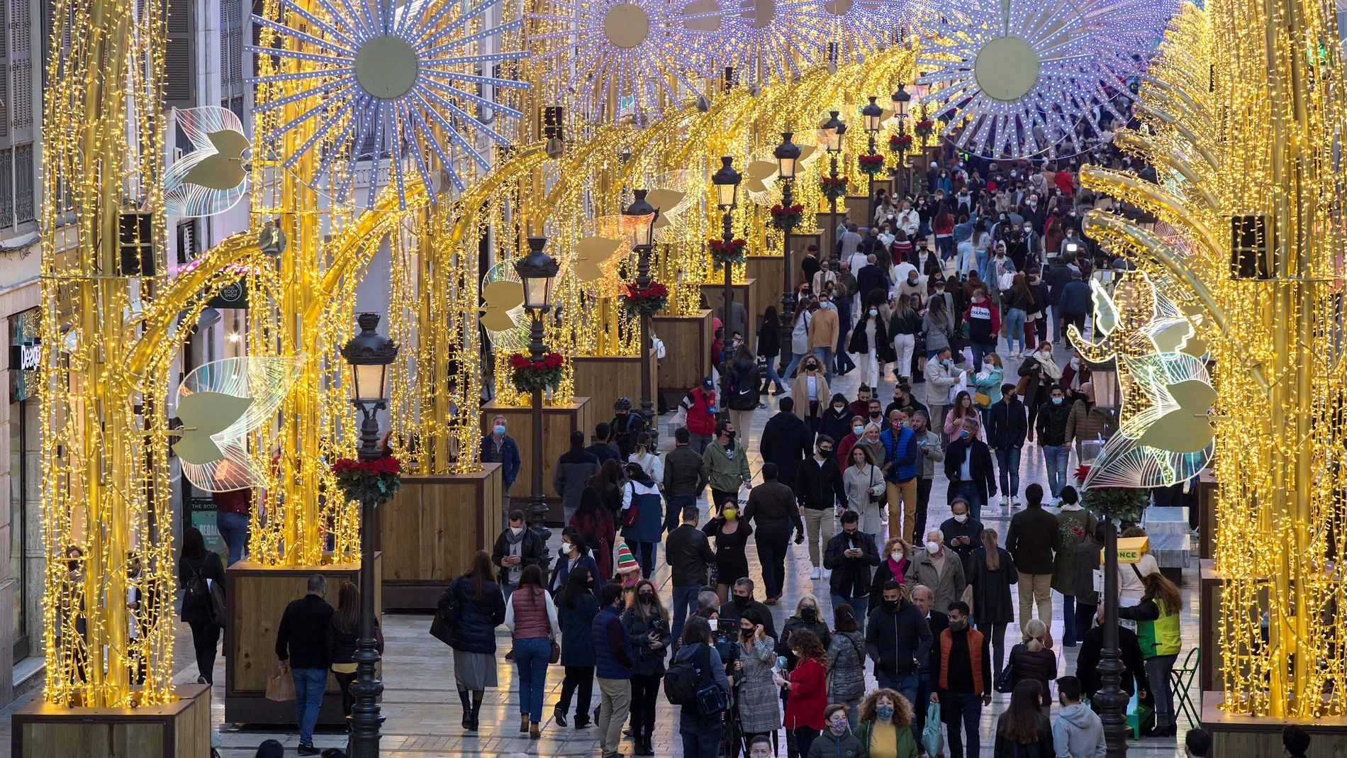 Numerosas personas observan el alumbrado de Navidad de la calle Larios, en Málaga