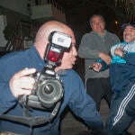 Argentina's Diego Maradona, right, reaches with his leg to try to kick photographer Enrique Garcia Medina, front, outside the home of Maradona's father in Buenos Aires, Argentina, Sunday, July 28, 2013. The man holding Maradona back is unidentified. Garcia Medina filed a police complaint alleging that the former soccer star and coach attacked him. (AP Photo/Caras Magazine) NO PUBLICAR EN ARGENTINA - NO PUBLICAR EN INTERNET - ARGENTINA OUT - ONLINE OUT