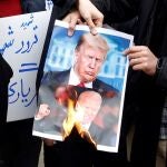 Varios estudiantes iraníes queman una foto del presidente de Estados Unidos, Donald Trump, y el presidente electo, Joe Biden
